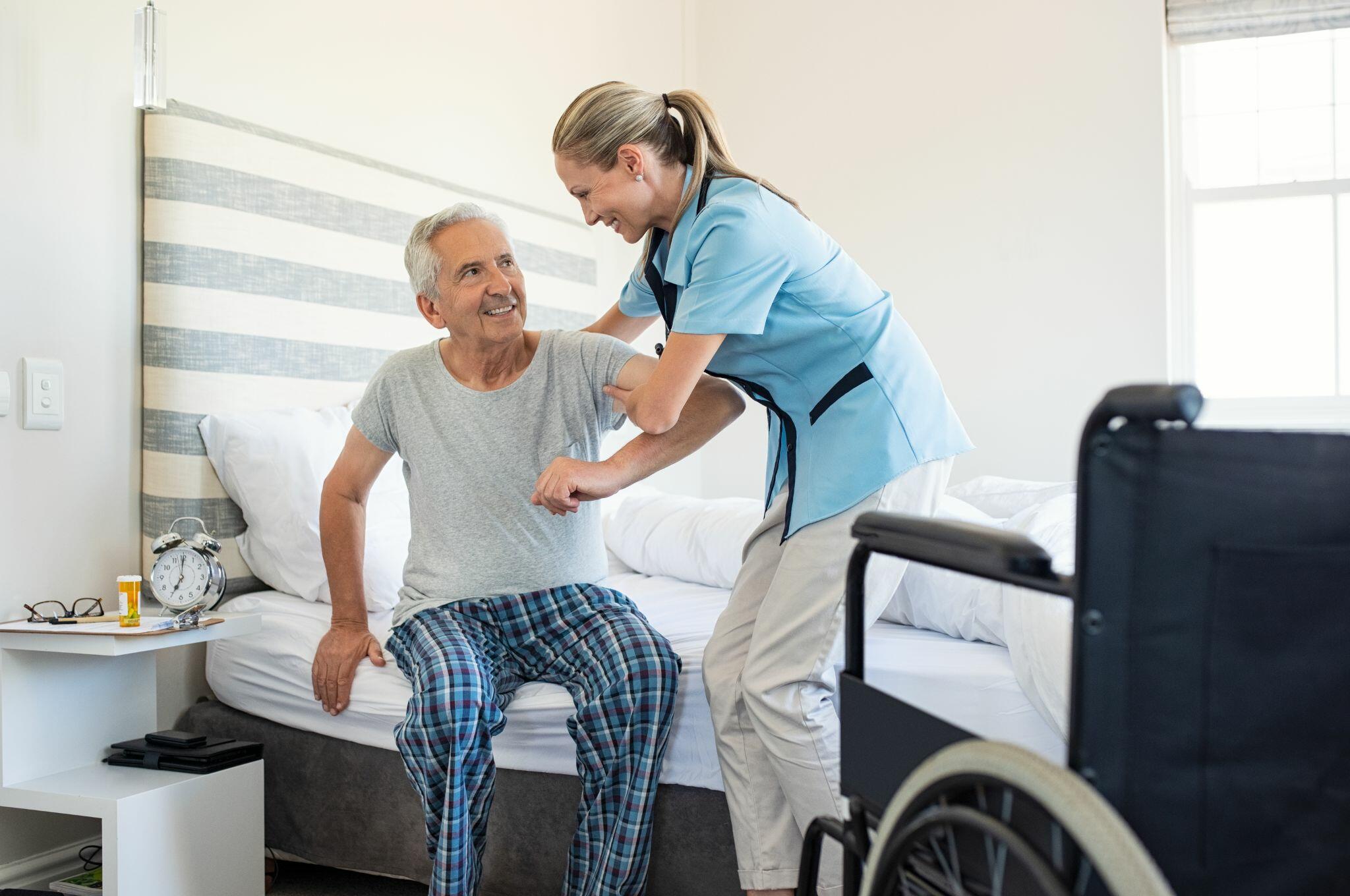 Nurse Helping Elderly Male Patient Stand Up