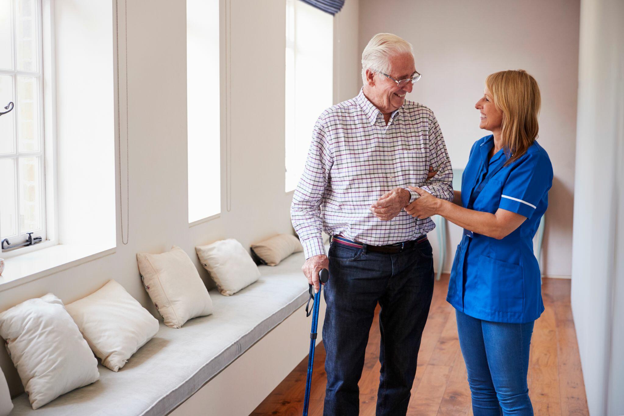 Nurse Helping Senior Man Using Walking Stick