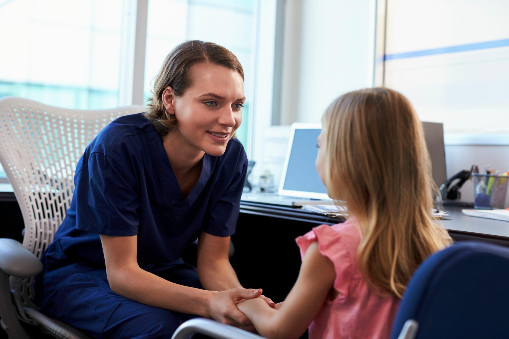 Pediatrician Talking to Female Child in Hospital
