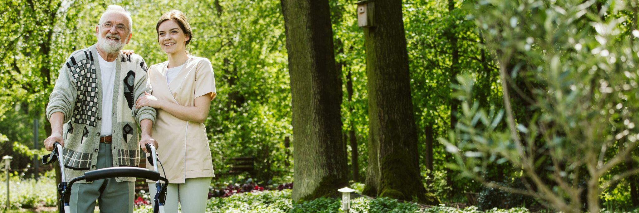 Senior Man being Walked around the Garden by Volunteer