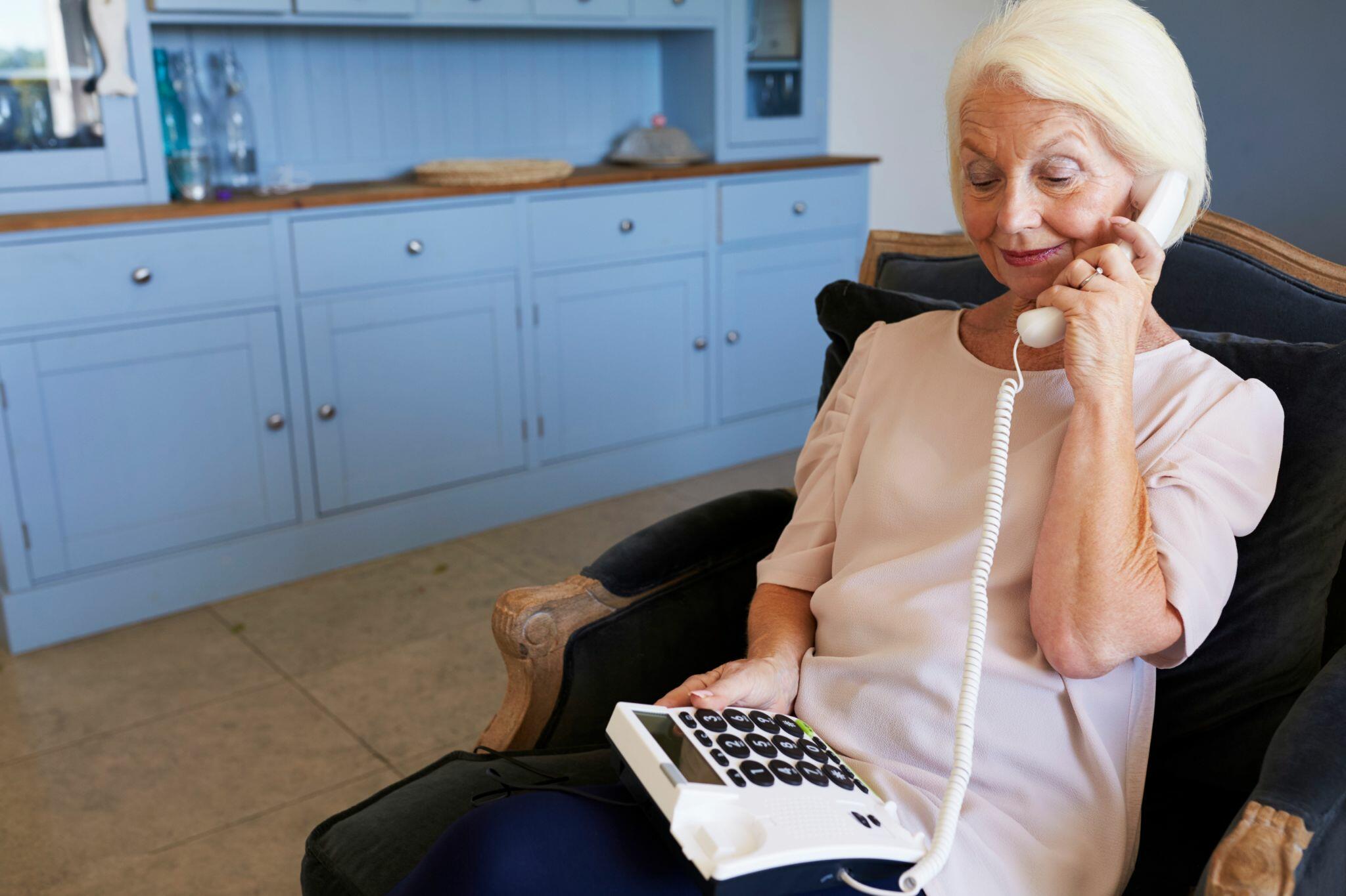 Senior Woman at Home using Telephone