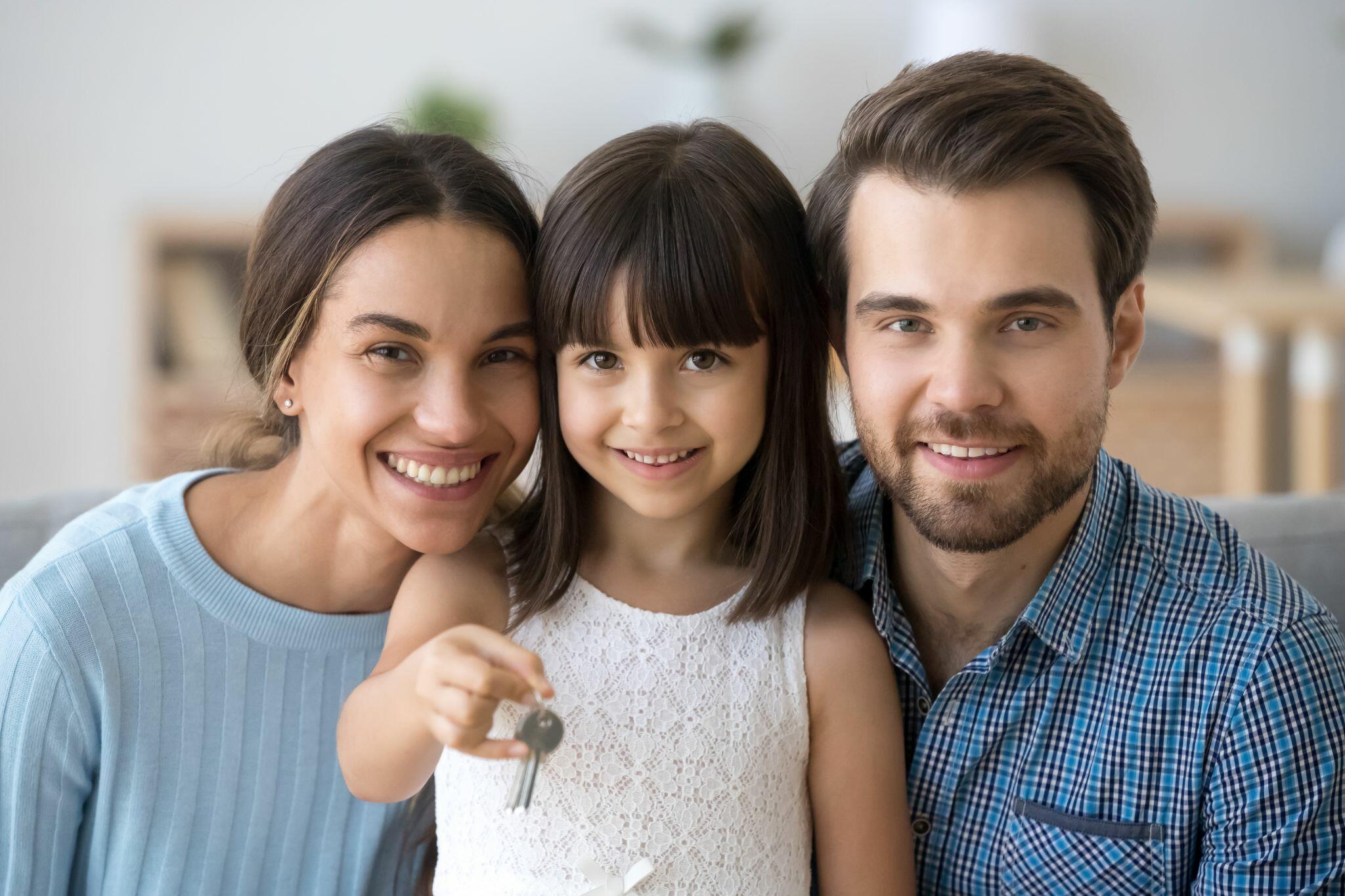 Image of a Dad & Mom smiling with their Daughter
