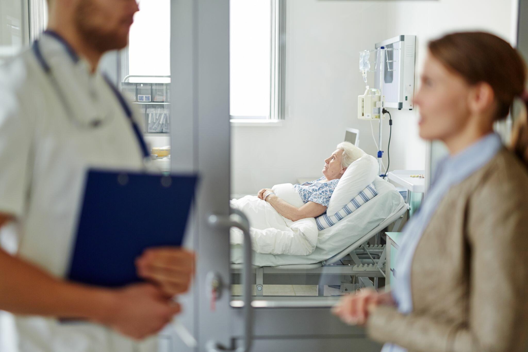 Women talking to Doctor to Visit Grandmother in Hospital
