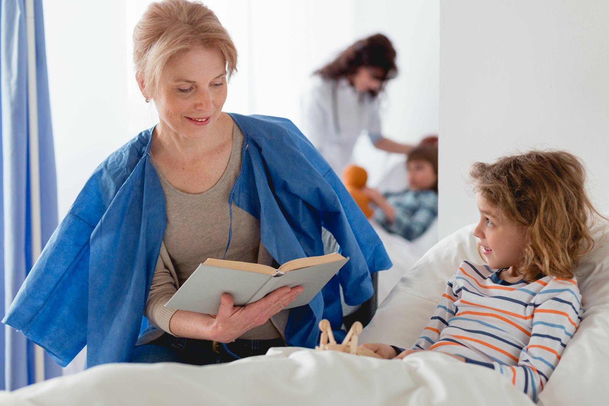 Woman reading Book to Daughter in Hospital
