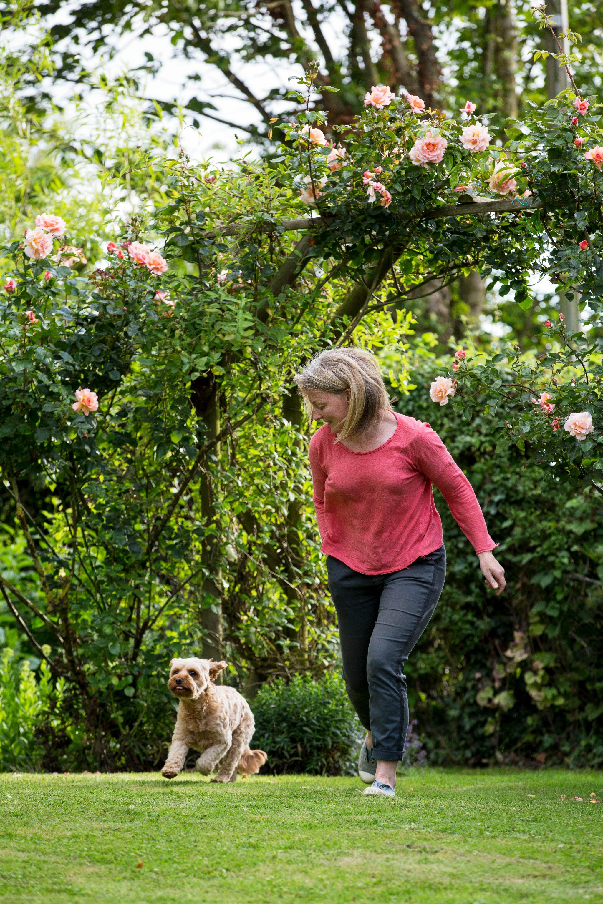 Woman playing with Dog in Garden